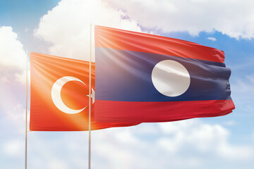 Sunny blue sky and flags of laos and turkey