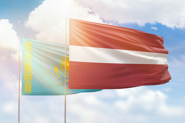 Sunny blue sky and flags of latvia and kazakhstan