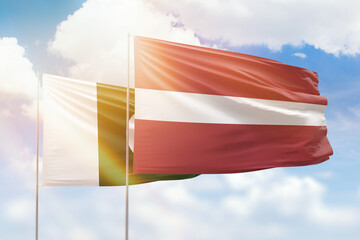 Sunny blue sky and flags of latvia and pakistan