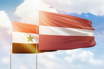 Sunny blue sky and flags of latvia and syria