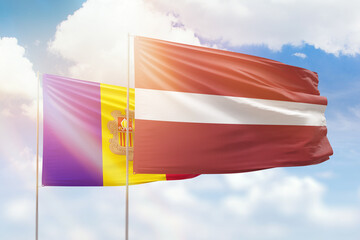Sunny blue sky and flags of latvia and andorra