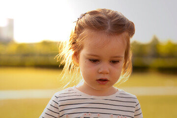 portrait of a baby girl waking on the grass 