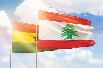 Sunny blue sky and flags of lebanon and ghana
