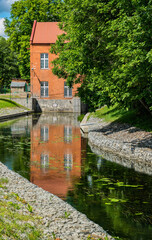Fototapeta na wymiar Old brick water mill on the river