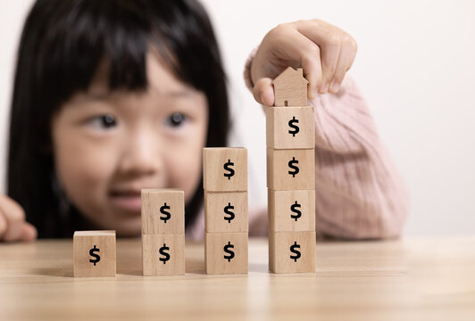 Close up children stack Wooden home icon and  block to upside bar graph with dollar icon. Concept for growth graph and property price.