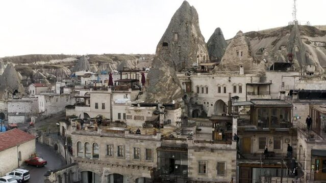 Ancient stone dwellings carved from tuff in Cappadocia, Turkey, aerial. Action. Aerial view of beautiful city with rock formations.