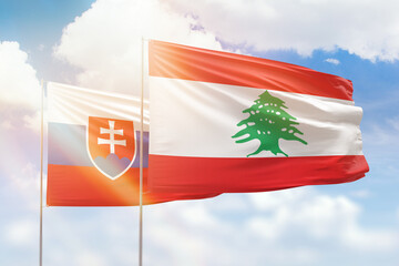 Sunny blue sky and flags of lebanon and slovakia
