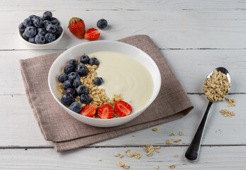 breakfast of yogurt and fresh strawberries and blueberries