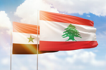 Sunny blue sky and flags of lebanon and syria