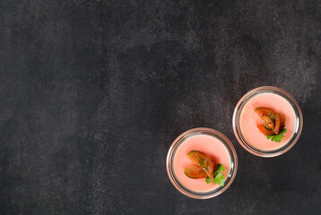 Obraz na płótnie Canvas Vegan dish. Tomato cream pudding, Panna Cotta in a glass. Dark gray background. Top view. Copy space
