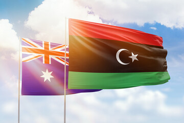 Sunny blue sky and flags of libya and australia