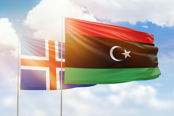 Sunny blue sky and flags of libya and iceland