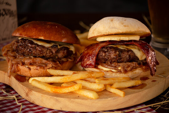 Dos hamburguesas con queso, tocineta y papas / Two burgers with cheese, bacon, and fries