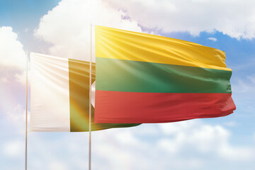 Sunny blue sky and flags of lithuania and pakistan
