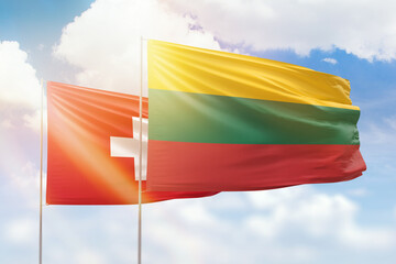 Sunny blue sky and flags of lithuania and switzerland