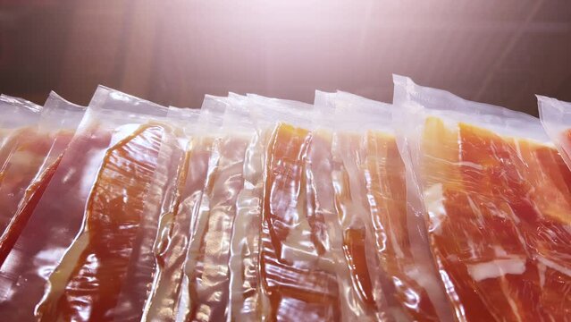 Iberian ham in vacuum plastic packs on a supermarket or grocery window. Close-up shot