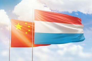 Sunny blue sky and flags of luxembourg and china