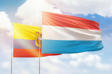 Sunny blue sky and flags of luxembourg and ecuador