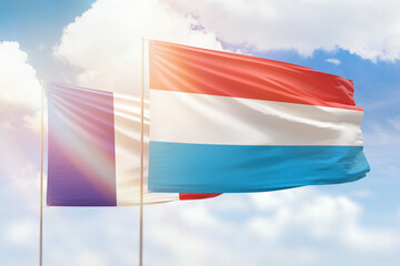 Sunny blue sky and flags of luxembourg and france