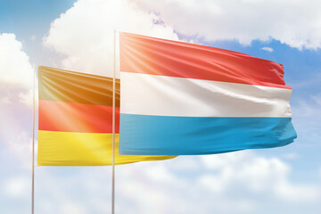 Sunny blue sky and flags of luxembourg and germany