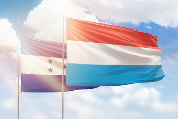 Sunny blue sky and flags of luxembourg and honduras
