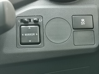 Photo of car side mirror button adjustment on the dashboard.