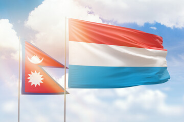 Sunny blue sky and flags of luxembourg and nepal
