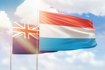 Sunny blue sky and flags of luxembourg and new zealand