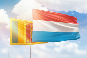 Sunny blue sky and flags of luxembourg and sri lanka