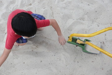 child wearing mask playing in the white sandpit design for covid-19 leisure time