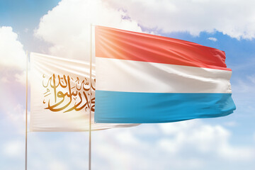 Sunny blue sky and flags of luxembourg and afghanistan