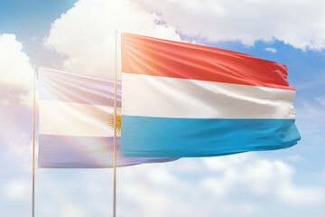 Sunny blue sky and flags of luxembourg and argentina