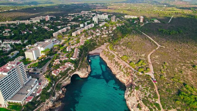 Modern build residence building with pool by the beach on rocky caves in Majorca. Carrer de Cala Antena, Cales de Mallorca, Balearic Islands, Spain.