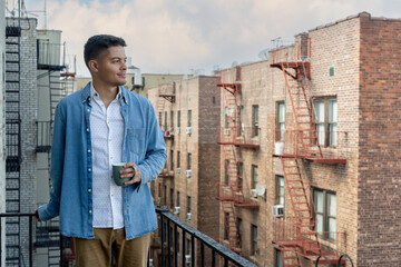 Young Biracial Latino Man Drinking Coffee on Fire Escape in Flatbush Brooklyn New York City