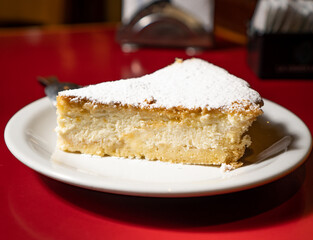 a portion of ricotta cake on a white dish.