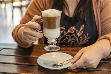 a woman drinking a cappuccino in a bar.