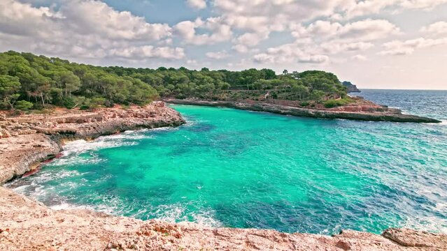 Mediterranean rocky beach with caves in Majorca, Spain with transparent water. Crystal clear sea with turquoise waters by Caló des Borgit beach on Mallorca, Balearic Islands.