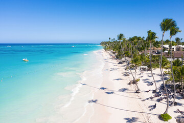Bounty coastline with resorts, palm trees, caribbean sea and people having fun on beach. Travel destinations. Dominican Republic. Aerial view