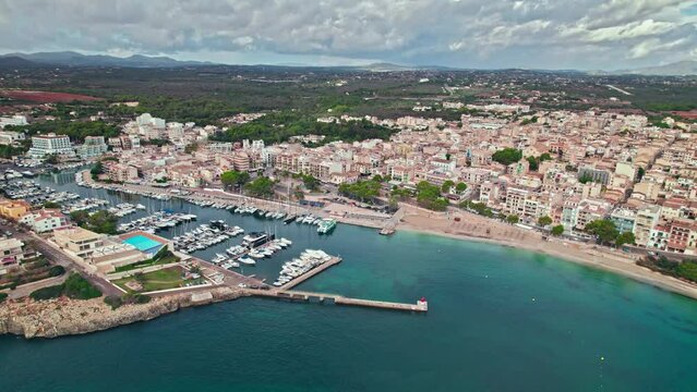 Scenic Porto Cristo Marina view from above with houses by the coast in Majorca. A view of a Spanish village known for amazing Drach Caves on the Balearic Islands, Spain.