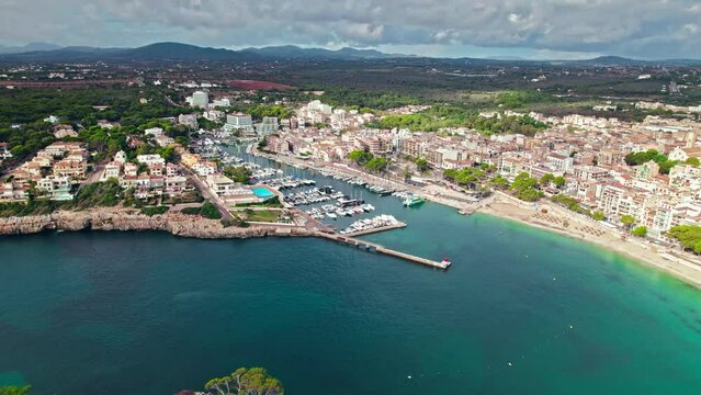 Scenic Porto Cristo Marina view from above with houses by the coast in Majorca. A view of a Spanish village known for amazing Drach Caves on the Balearic Islands, Spain.