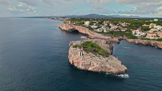 Beautiful view of coastal Porto Cristo village from above on Majorca Island. Torre del Serral dels Falcons by Drach Caves in Balearic Islands, Spain.