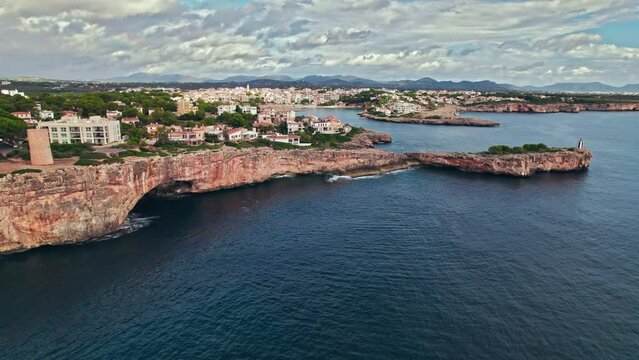 Beautiful view of coastal Porto Cristo village from above on Majorca Island. Torre del Serral dels Falcons by Drach Caves in Balearic Islands, Spain.