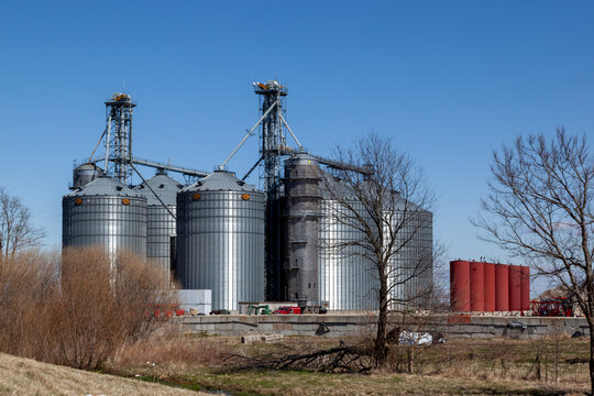 Illinois, USA - March 26, 2022: GSI storage grain bins are seen in the farm in Illinois, USA. GSI is an American manufacturer of steel farm bins, storage grain bins, grain silos and more.