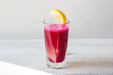 glass with beetroot red juice on white background