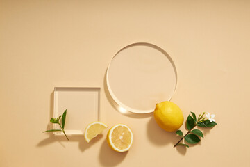Top view of lemon decorated with transparent podium and green leaf blank space for advertising 