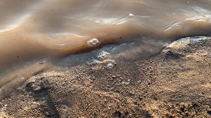The texture of the river water hitting the mainland in the morning