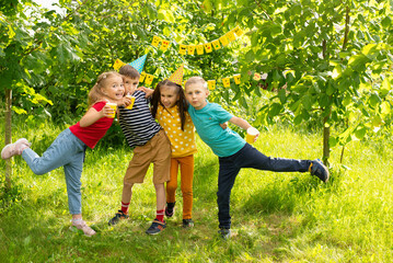 Fototapeta premium World Smile Day and a children's holiday, children have fun at a picnic in the summer,a cheerful company of children show emojis 