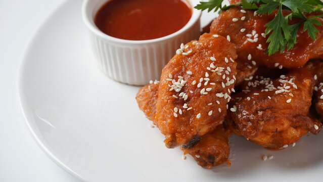 Fried Chicken Wings on a white plate with spices and dip. Hot Meat Dishes