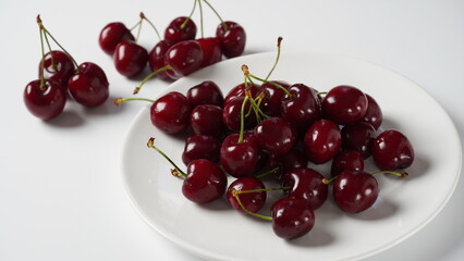 Sweet red cherries on a plate, fresh ripe sour cherries.