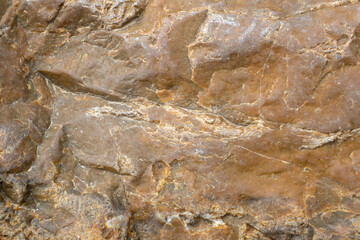 Obraz na płótnie Canvas The texture of the surface of the stone closeup. Abstract brown background.
